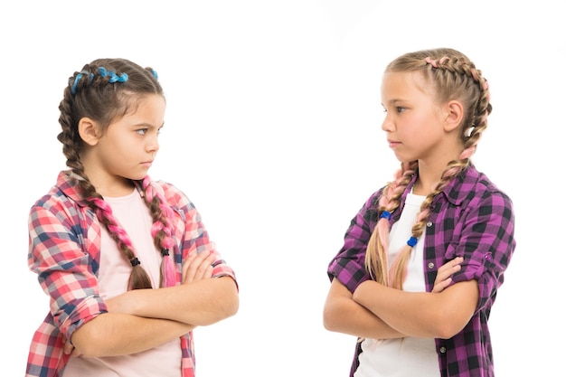Kids sisters looks strictly Girls folded arms on chest looks serious white background Stubborn temper Stubborn concept Stubborn kids Disagreement and stubbornness Girls offended friends