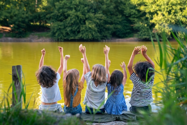 사진 호수 뒷모습에 앉아있는 아이들