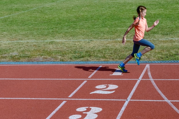 Kids sport, kind draait op stadion track, training en fitness concept