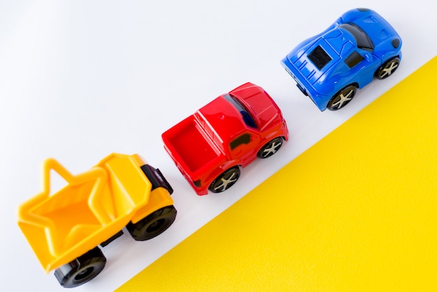 Photo kids toys cars on white and yellow.