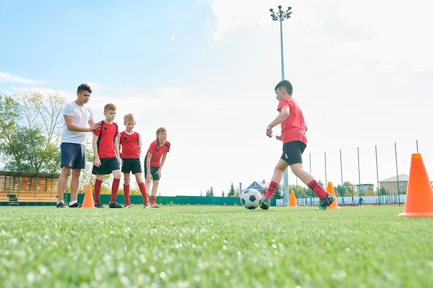 フットボールスクールでトレーニングする子供たち