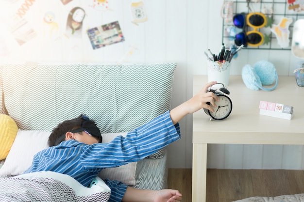 A kids waking up to an alarm clock in the bedroom