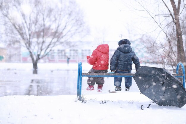 写真 子供たちは最初の雪で公園を歩く