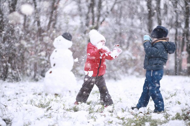 Photo kids walk in the park first snow