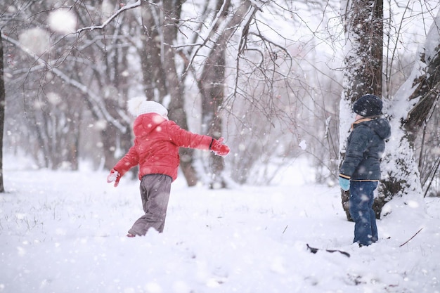 子供たちは公園の最初の雪を歩く