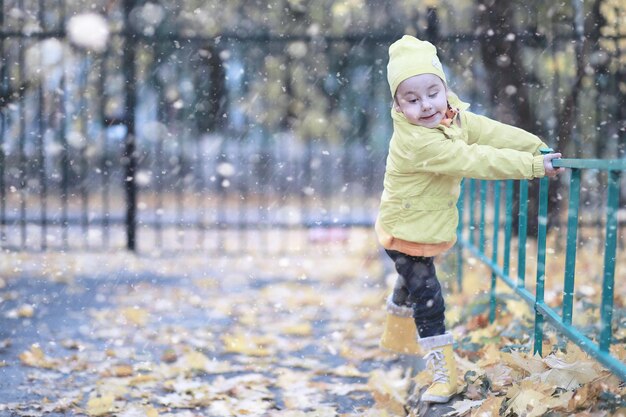 Photo kids walk in the park first snow