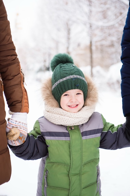 子供たちは最初の雪で公園を歩きます。