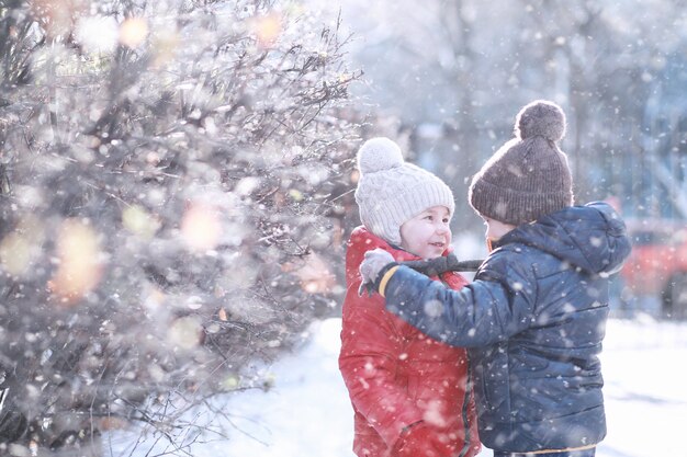 아이들은 첫 눈이 내리는 공원을 걷습니다.