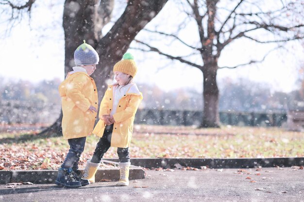 子供たちは最初の雪で公園を歩く