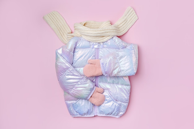 Kids warm puffer jacket with scarf  on pink background. Stylish childrens outerwear. Winter fashion outfit