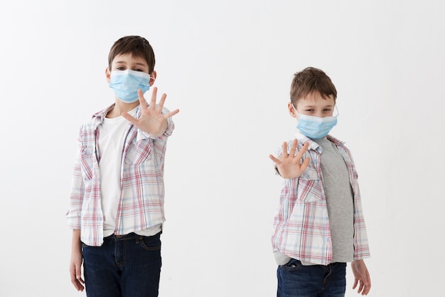 사진 깨끗 한 손을 보여주는 의료 마스크를 착용하는 아이