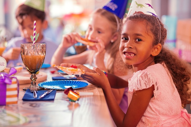 Kids wearing party hats and enjoying the food