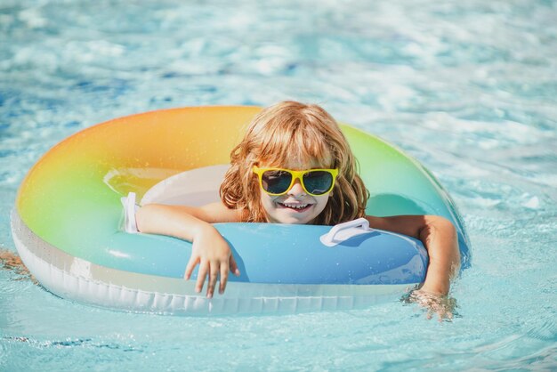 アクアパークスイミングプールの夏休みで子供の週末の男の子