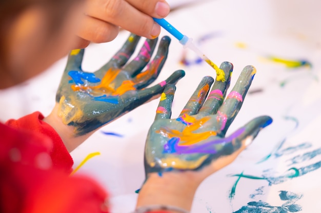 Foto bambini con mano sporca dipinta in aula d'arte