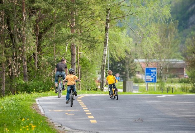 父親が自転車に乗っている子供たち