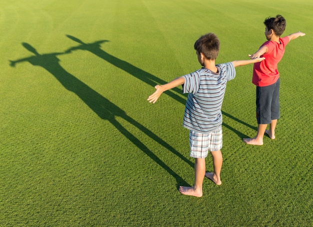芝生の上に影を持つ子供たち