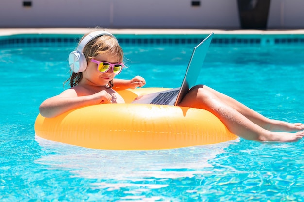 여름 방학에 노트북으로 일하는 아이들은 컴퓨터 원격 작업을 사용하는 작은 프리랜서