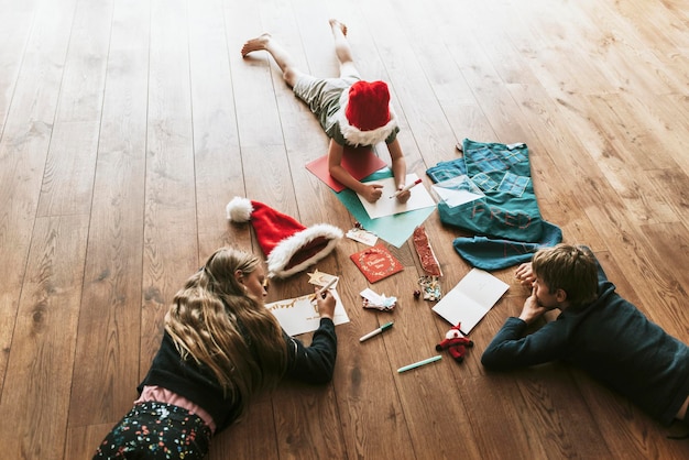 나무 바닥에 크리스마스 카드를 쓰는 아이들