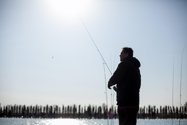 Kiev, Oekraïne, 16 april 2018. Kaukasische visser vangt vis met een spinhengel op het meer.