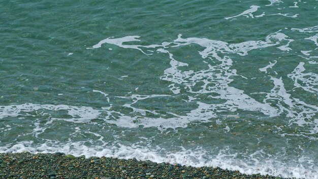 Kiezels strand en zee golven golven wassen de kiezels strand rustige zee oppervlak nog