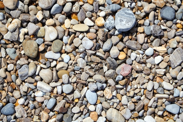 Kiezelstenen op het strand. Gladde stenen in verschillende maten en kleuren. Bovenaanzicht