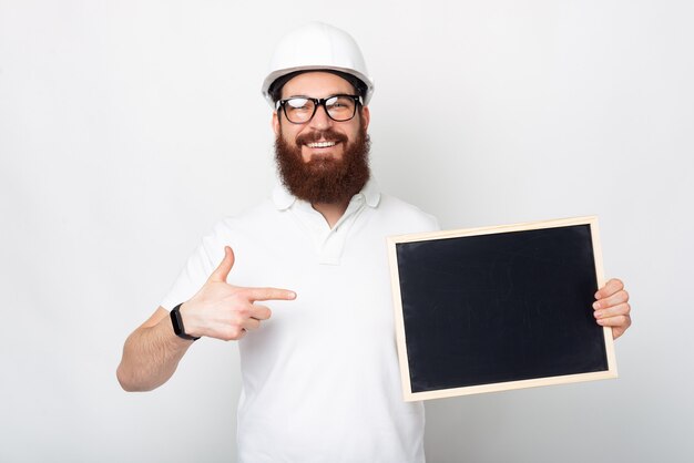 Kijk hier eens naar, zegt een jonge man met een helm op die naar een schoolbord wijst.