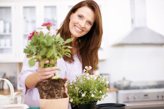 Kijk hoe gemakkelijk dit is Portret van een mooie vrouw die wat planten oppot voor de zomer