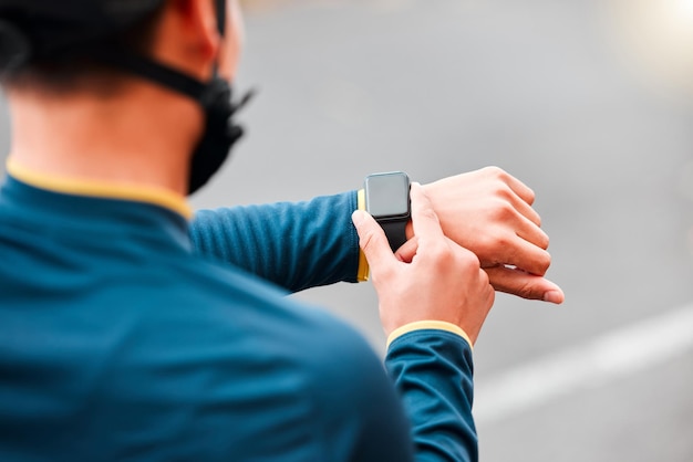 Kijk naar fitness en man die een trainingsoefening doet of cardio buiten op de stadsweg voor motivatie Handen van een atleet met monitor van tijd tijdens training met sporttechnologie op straat