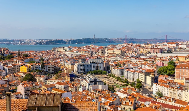 Kijk naar het centrum van Lissabon met meerdere straten en huizen en brug van 25 april over de Tagys-rivier Portugal