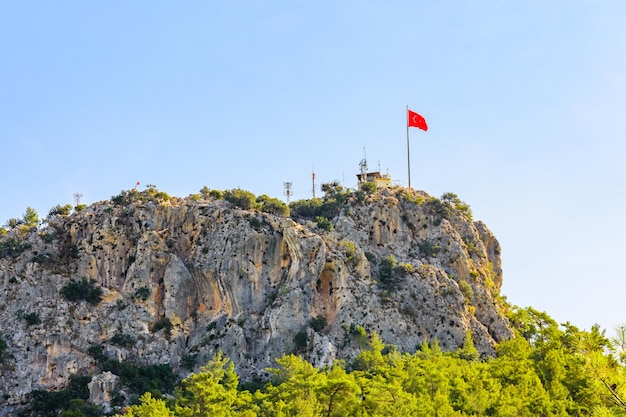 Kijk op de berg Chalish en de Turkse vlag op de top, niet ver van de stad Kemer in de provincie Antalya, Turkije