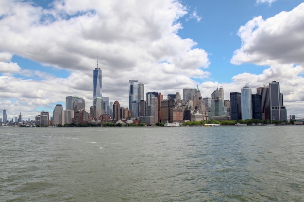 : Kijk op de zeilboot die op de achtergrond door New Yorkse havengebouwen van het eiland Manhattan vaart.