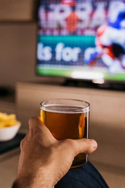 Foto kijken naar voetbal concept met hand met bier