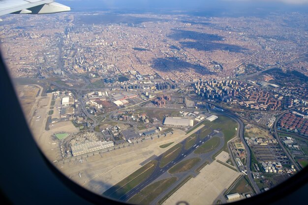 Kijkend door raamvliegtuigen tijdens de vlucht over Istanbul bij zonnig weer