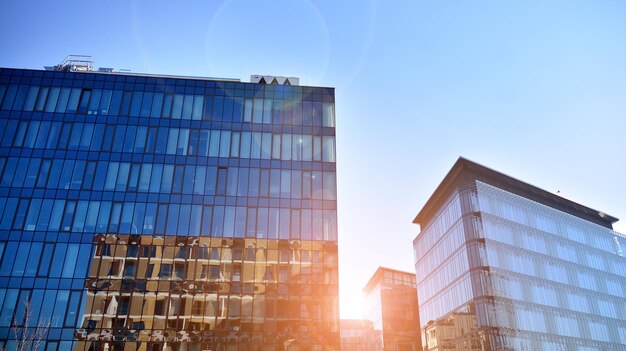 Kijkend naar de commerciële gebouwen in het centrum Modern kantoorgebouw tegen de blauwe hemel
