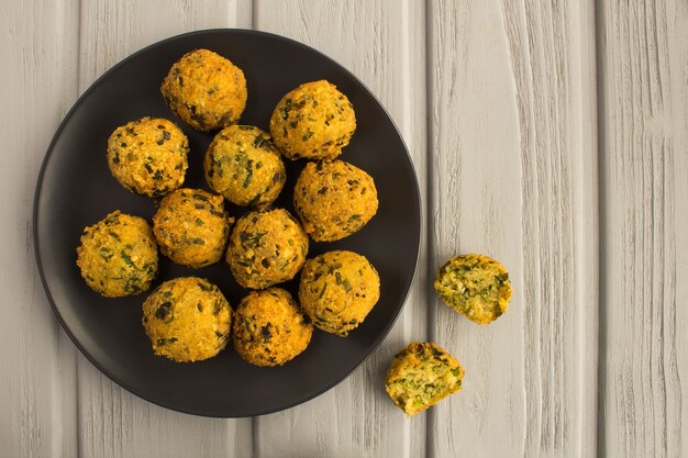 Kikkererwten falafel in de donkere plaat op de grijze houten achtergrond. Bovenaanzicht. Kopieer ruimte.