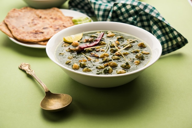 Kikkererwten Spinazie Curry of Chana Masala met Palak geserveerd met rijst en flatbread of Paratha, selectieve focus