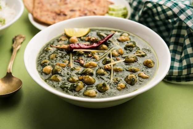 Kikkererwten Spinazie Curry of Chana Masala met Palak geserveerd met rijst en flatbread of Paratha, selectieve focus