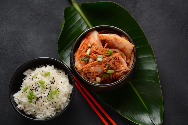 Kimchi and rice in black bowl with chopstick Korean food