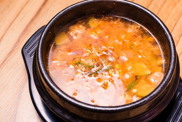 Kimchi-soep in hete zwarte ijzeren pot Koreaanse traditionele Kimchi Jjigae-soep in kom in het restaurant?