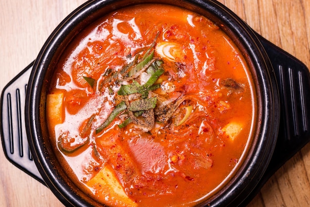 Kimchi-soep in hete zwarte ijzeren pot Koreaanse traditionele Kimchi Jjigae-soep in kom in het restaurant?