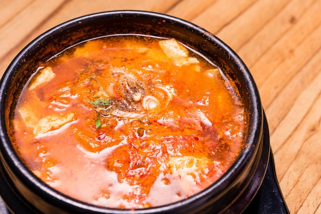 사진 뜨거운 검은 철 냄비에 김치 수프 식당에서 그릇에 한국 전통 김치 찌개 수프