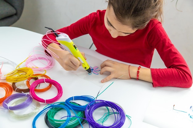 Kind 3d tekeningen met een pen op tafel selectieve focus