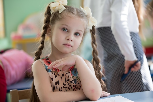 Kind aan tafel met een notitieboekjebasisschoolleerling