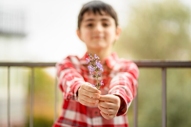 Kind biedt een geurig takje bloeiende salie cadeau