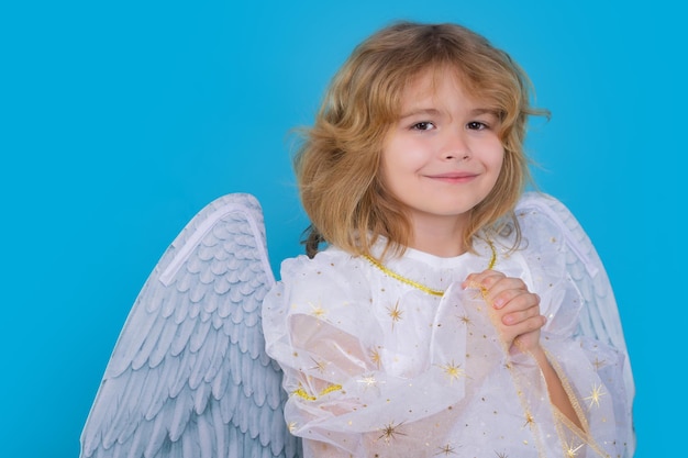Foto kind bij engelenkostuumjong geitje met engelenvleugels met gebedshanden hoop en bid concept geïsoleerde studio