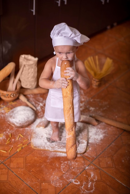 kind bijt een brood in een kokskostuum