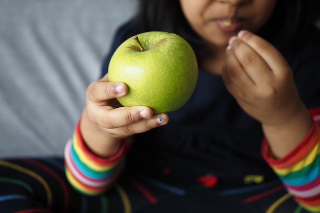 Kind bijt een groene appel van dichtbij