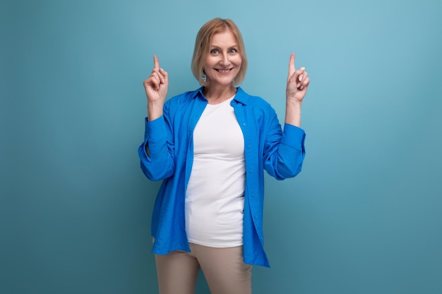 Kind cute middle aged woman in casual shirt on blue background