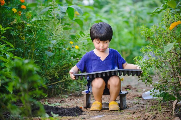 kind dat groenten plant in een dienbladconcept van leeractiviteit voor kinderen thuis