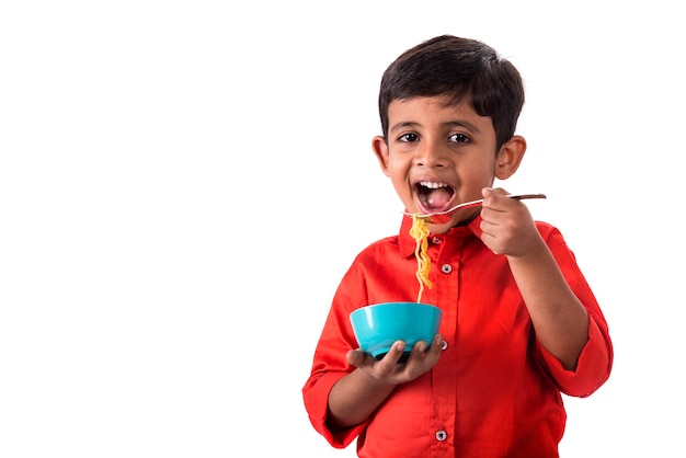 Kind dat heerlijke noedels eet, Indisch Kind dat noedels met vork op wit eet